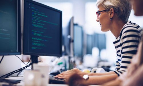 Profile-view-of-young-female-programmer-working-on-computer-software-in-the-office.-1125595211_2125x1416